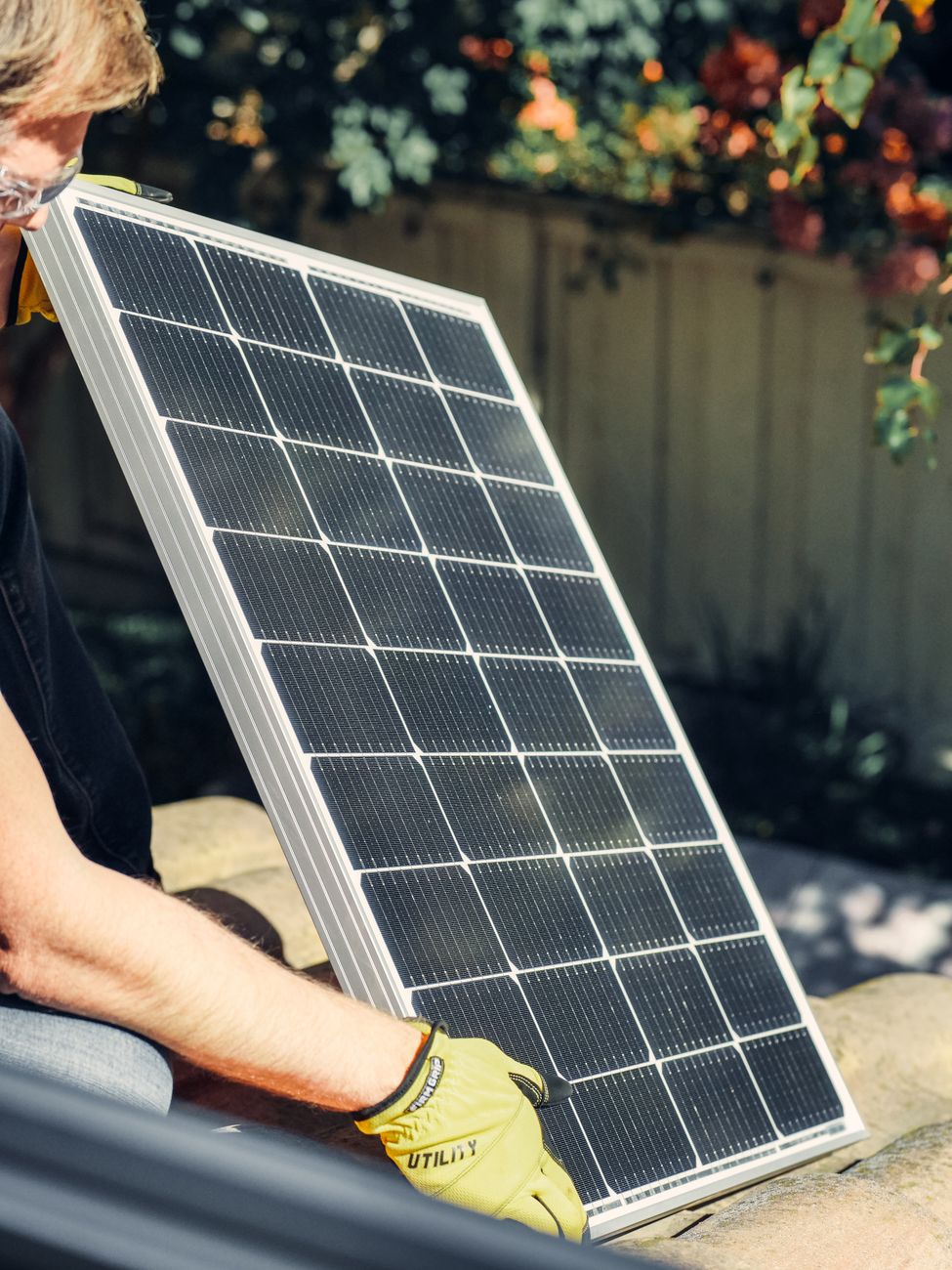 A person setting up a small plug-in solar panel kit